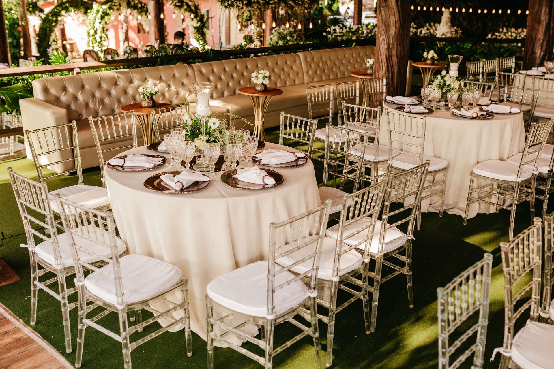 Sophisticated outdoor restaurant setup with white chairs, arranged tables, and elegant decor.