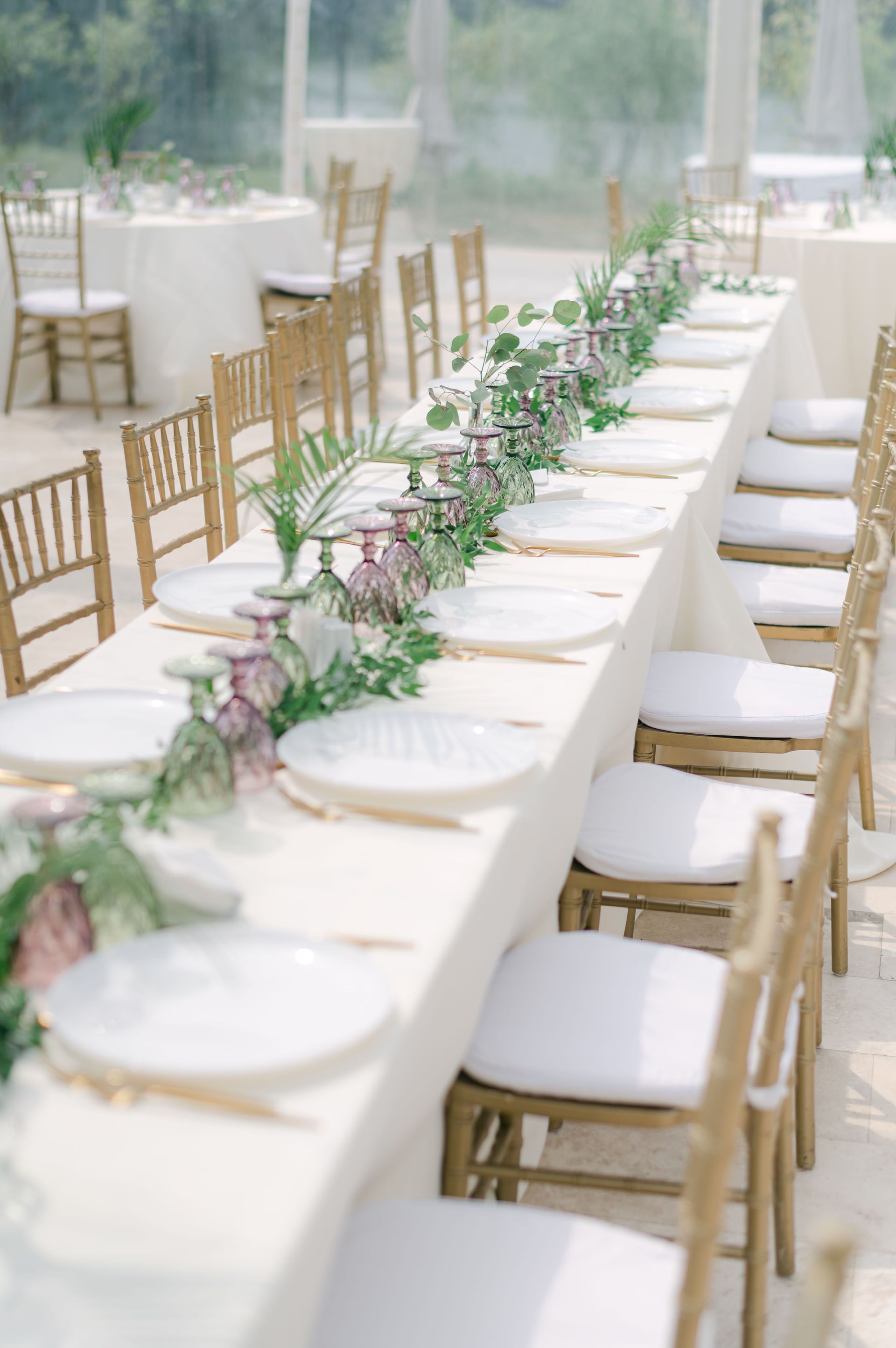 Beautiful outdoor wedding table with floral decorations and glassware.