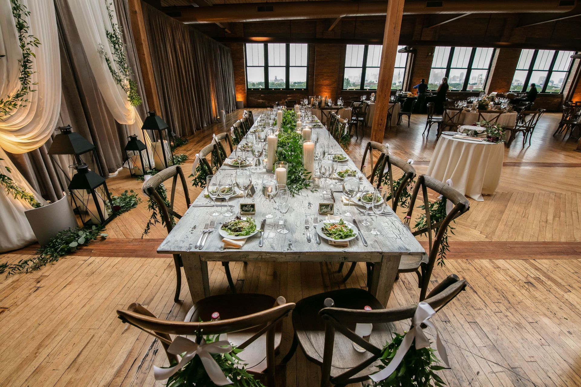 Stylish wedding reception table setup in a Chicago loft with candles and greenery.
