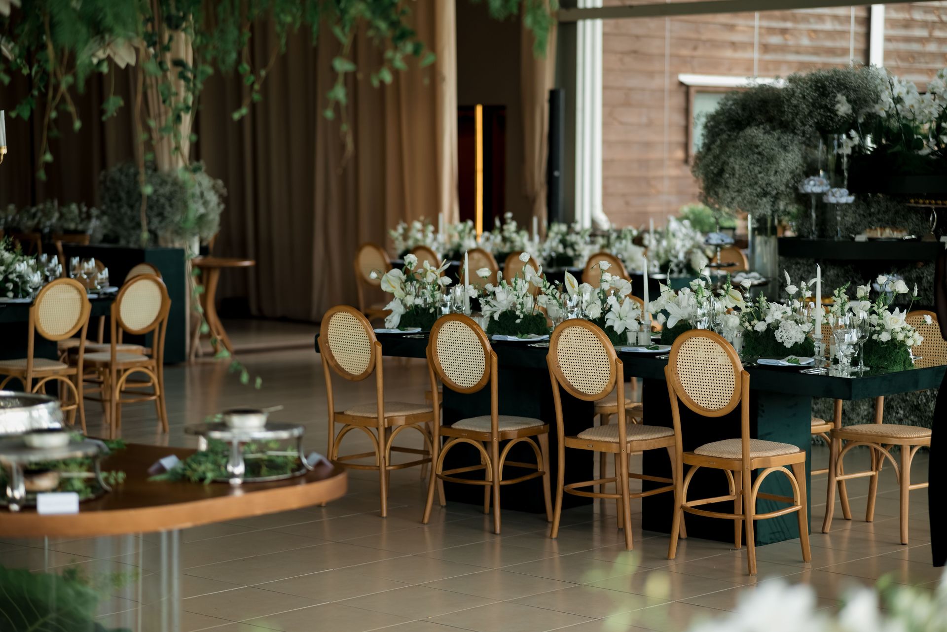 Beautifully decorated indoor wedding reception with floral arrangements and elegant seating.